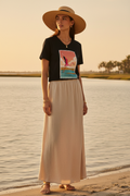 Femme portant le t-shirt Flamingo Coast, ambiance golden hour bord de mer